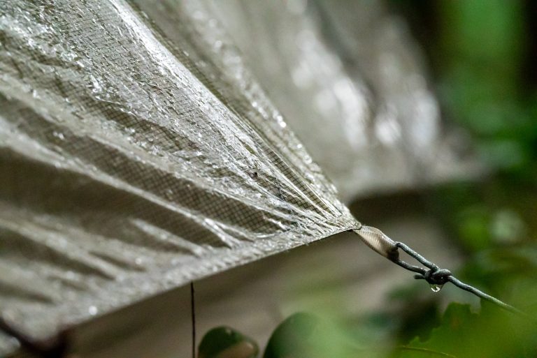 Regendruppel aan de scheerlijn van een tent tijdens het kamperen langs de weg in Japan.